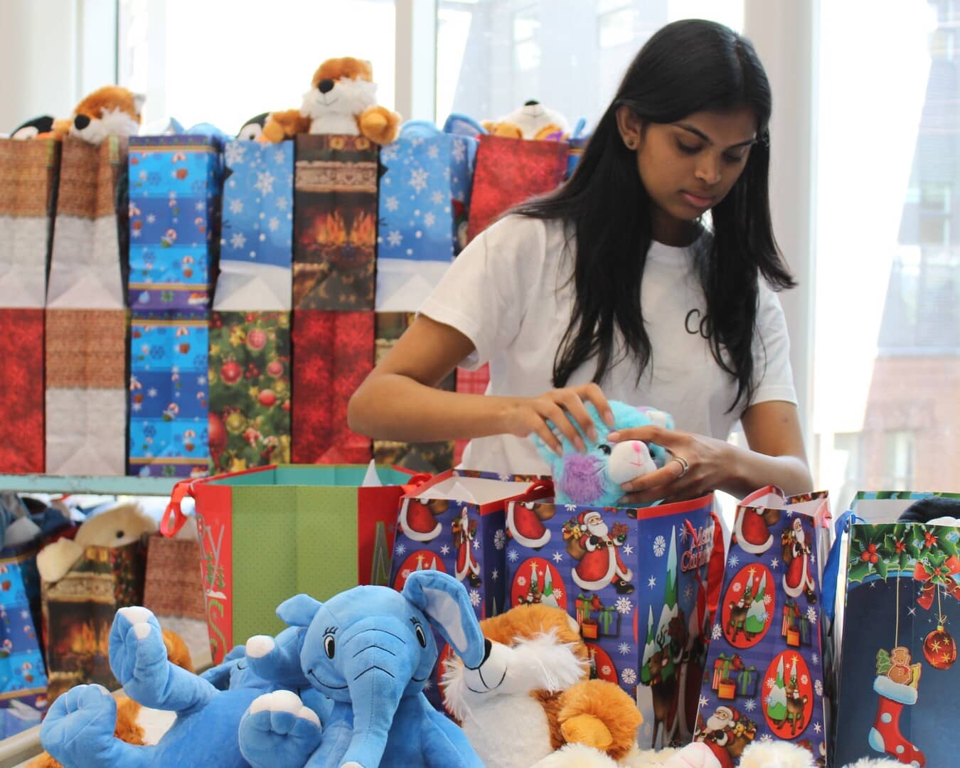 Un de nos membres qui assemble des sacs-cadeaux lors de notre événement Noël en juillet 2024