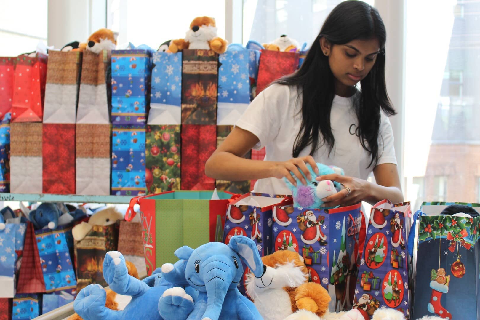 Un de nos membres qui assemble des sacs-cadeaux lors de notre événement Noël en juillet 2024