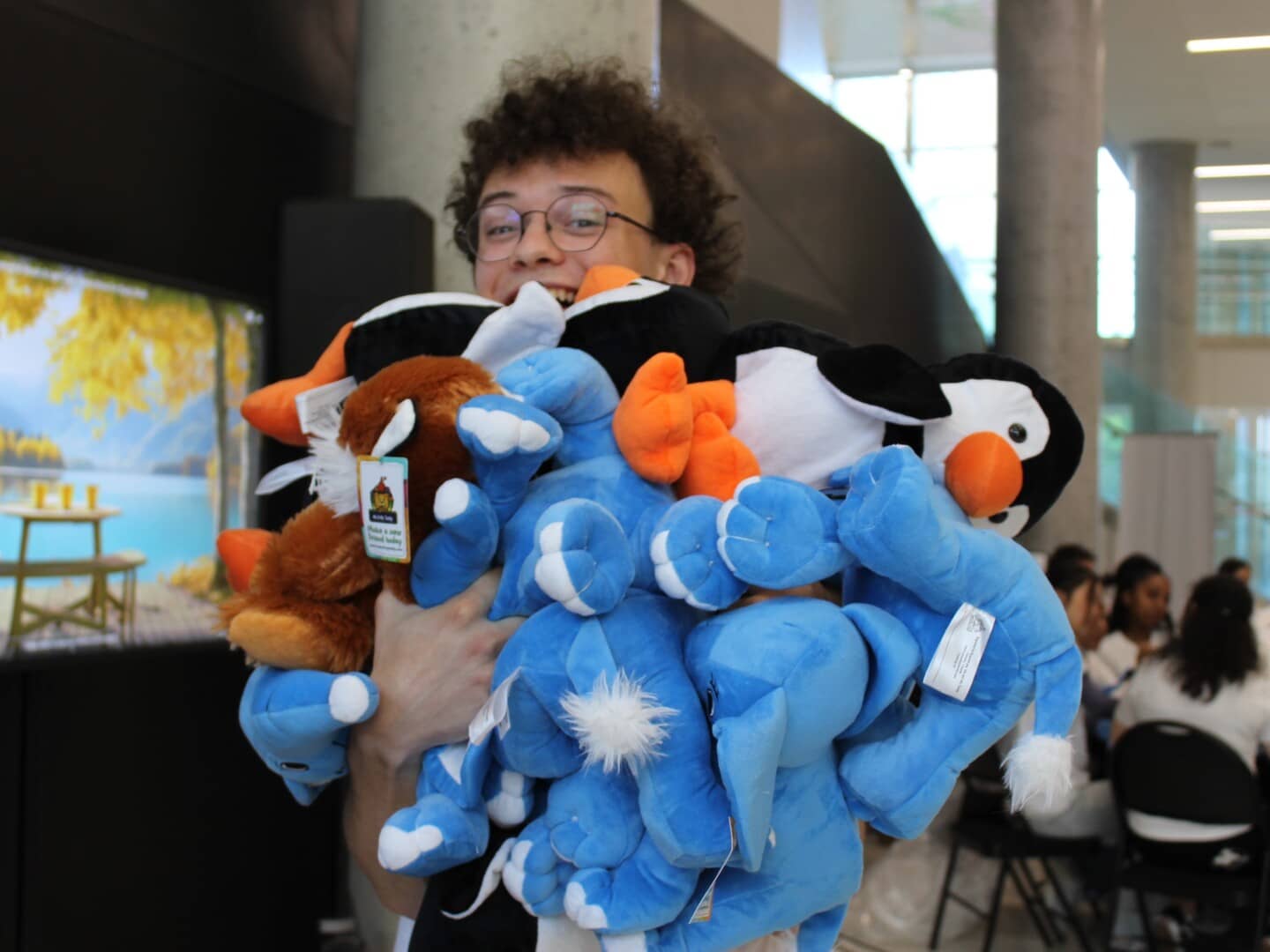 Un de nos membres avec plusieurs oursons en peluche dans les bras durant notre événement Noël en juillet 2024