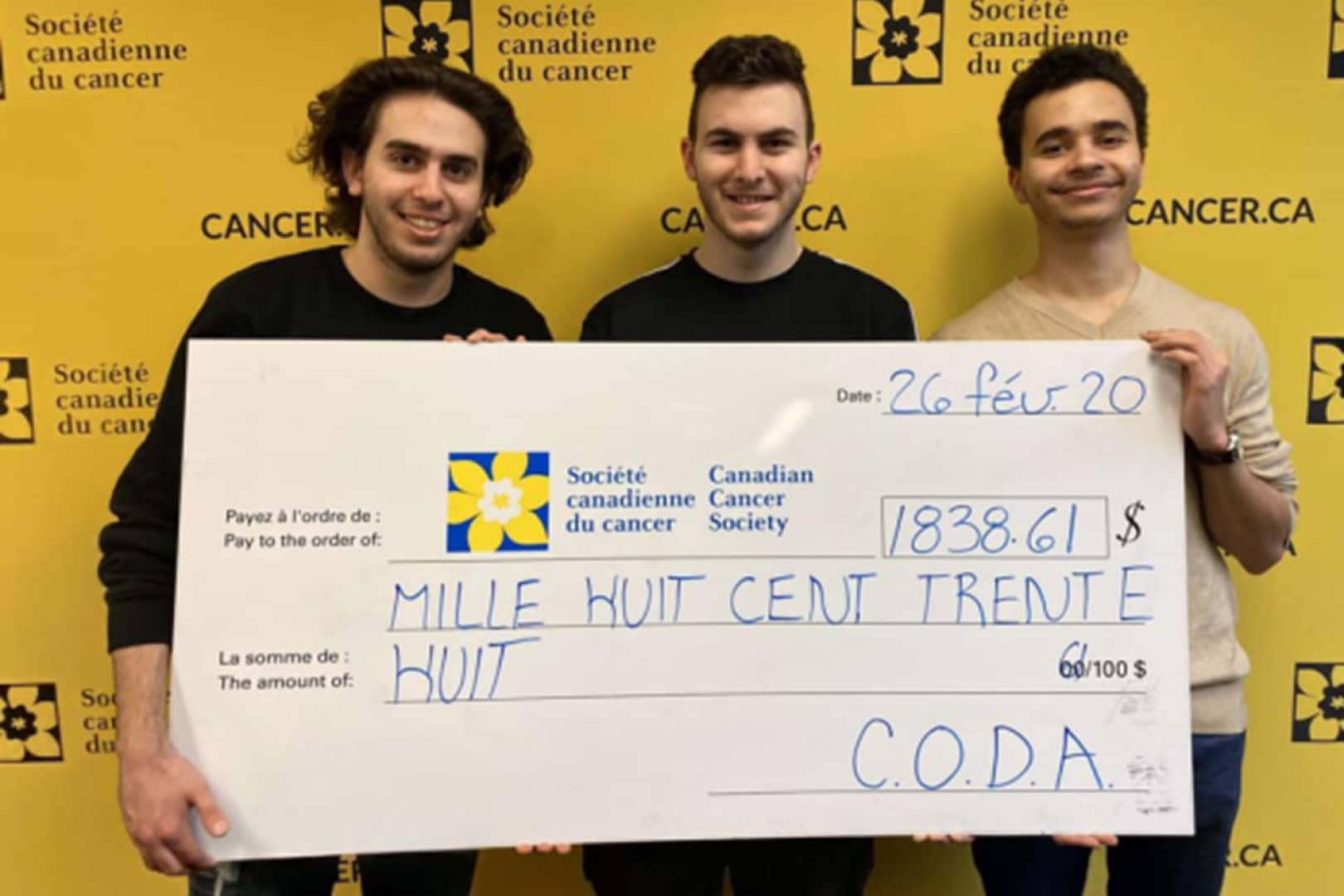 Les membres du comité CODA à Marianopolis tenant un large chèque au profit de la Société canadienne du cancer